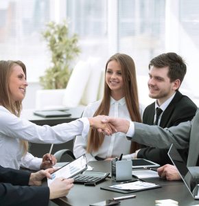 welcome handshake of business partners at the negotiating table in the office.